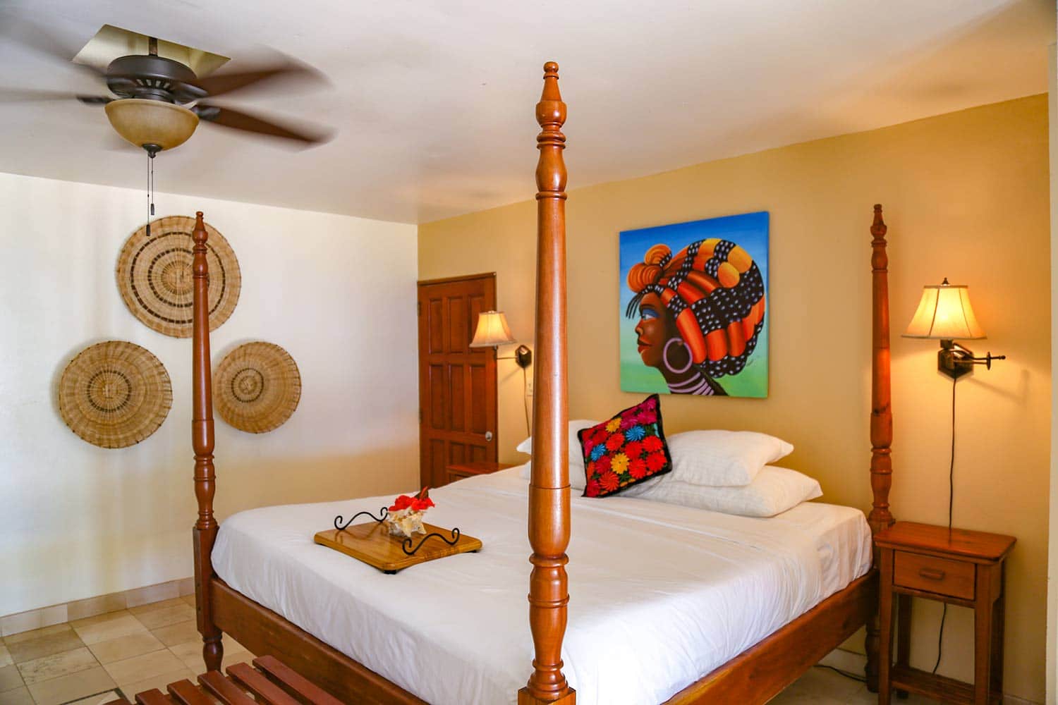 A queen sized bed inside one of the rooms at Almond Beach Resort