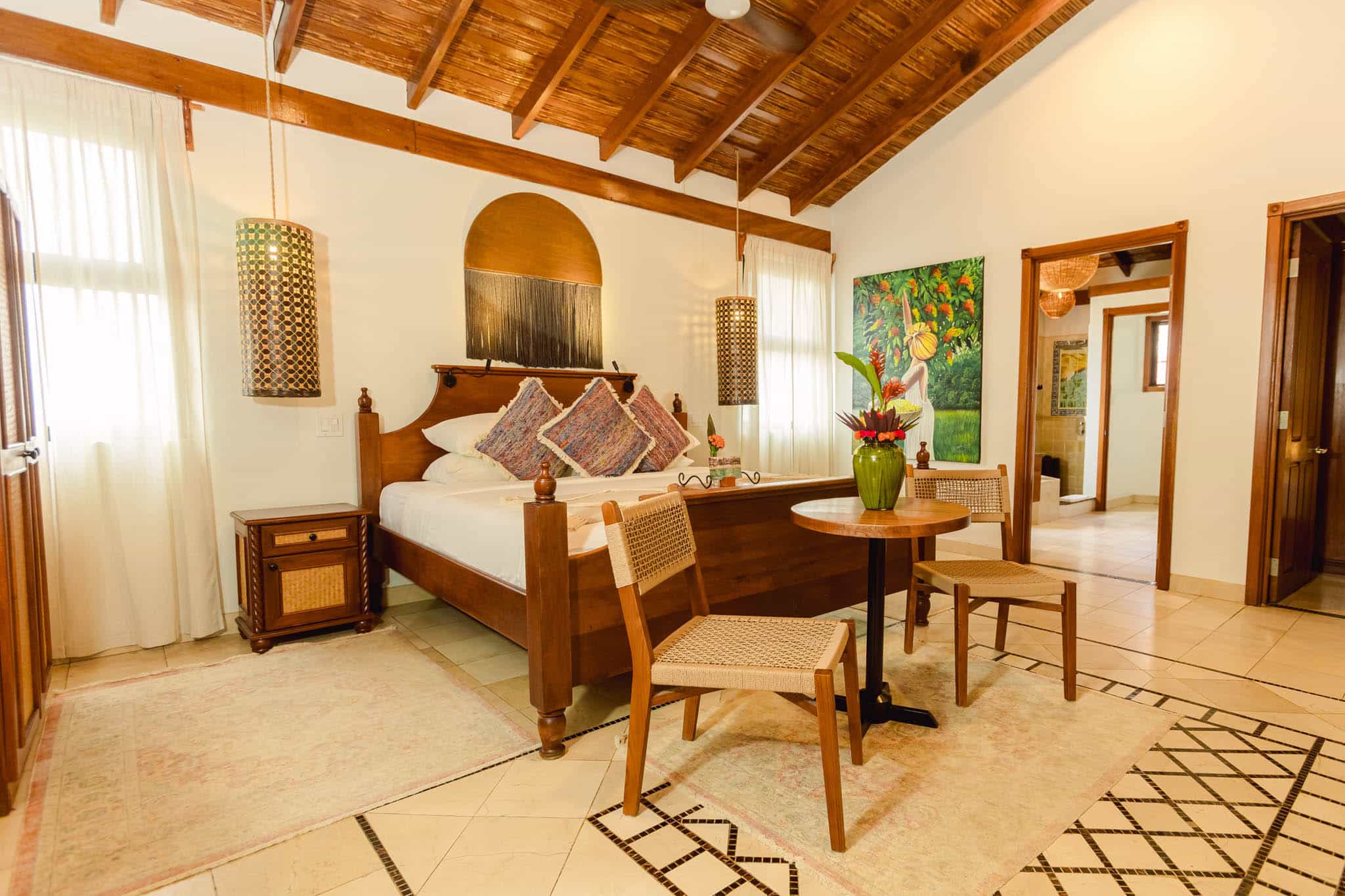 Comfortably furnished queen bed interior of the Garden View Room at The Resort at Almond Beach, Hopkins Village, Stann Creek District, Belize