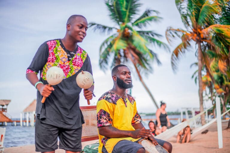 Authentic Garifuna musicians playing traditional shaka and drums on the Caribbean shore at The Resort at Almond Beach, Hopkins Village, Stann Creek District, Belize